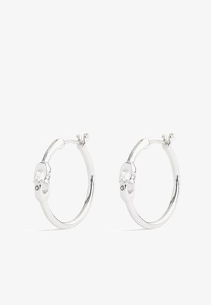 Orecchini a cerchio in argento con un design liscio e arrotondato, dotati di una chiusura a scatto. Piccole decorazioni evidenti vicino alla chiusura.