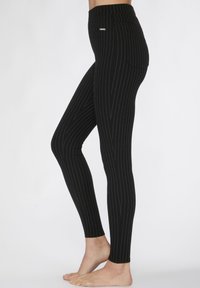 Zwarte leggings met verticale witte streepjes, hoge tailleband, aansluitend ontwerp en achterzakdetail. Gemaakt van rekbaar, zacht materiaal.