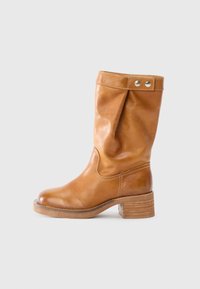 Bota de cuero marrón claro hasta la rodilla con un diseño arrugado, puntera redondeada y un tacón grueso apilado. Presenta un detalle de broche en la parte superior.