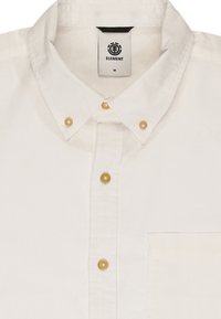 Biała koszula z guzikami i kołnierzykiem, z sześcioma guzikami, kieszenią na klatce piersiowej oraz metką z napisem "ELEMENT" przy dekolcie. Gładka tekstura materiału.