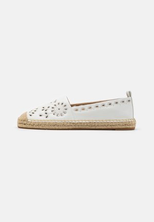 Hvide slip-on espadriller med blomsterudskæringsmønstre og flettet jutesål på ensfarvet baggrund.
