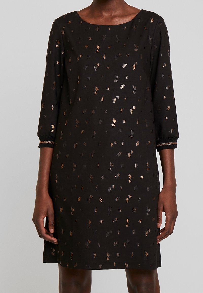 Robe noire à manches trois-quarts, ornée d'un motif floral métallique en or et en bronze. Tissu lisse et décolleté bateau.