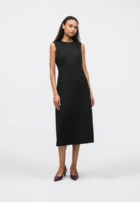 Černé midi šaty bez rukávů s jednoduchým střihem a kulatým výstřihem. Vyrobené z hladké látky se skrytými bočními kapsami.