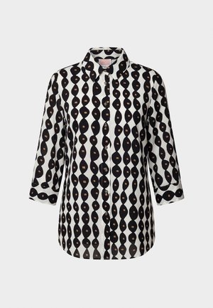 Sort-hvid skjorte med knapper og 3/4-ærmer, der har et bølget vertikalt stribemønster med små brune firkanter.