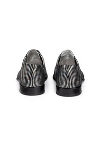 Chaussures d'Orsay métalliques avec un motif perforé noir et blanc, arrière fermé et doublure intérieure lisse en argent. Semelle noire robuste.