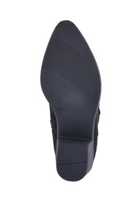 Suela de zapato negra con una superficie lisa y texturada, con una punta afilada y un tacón modesto. Son visibles sutiles estrías para proporcionar tracción.