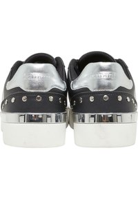 Sneaker neri con dettagli metallici argento, ornamenti a borchie e suola piatta bianca. Presentano una parte superiore liscia e un tallone texture.