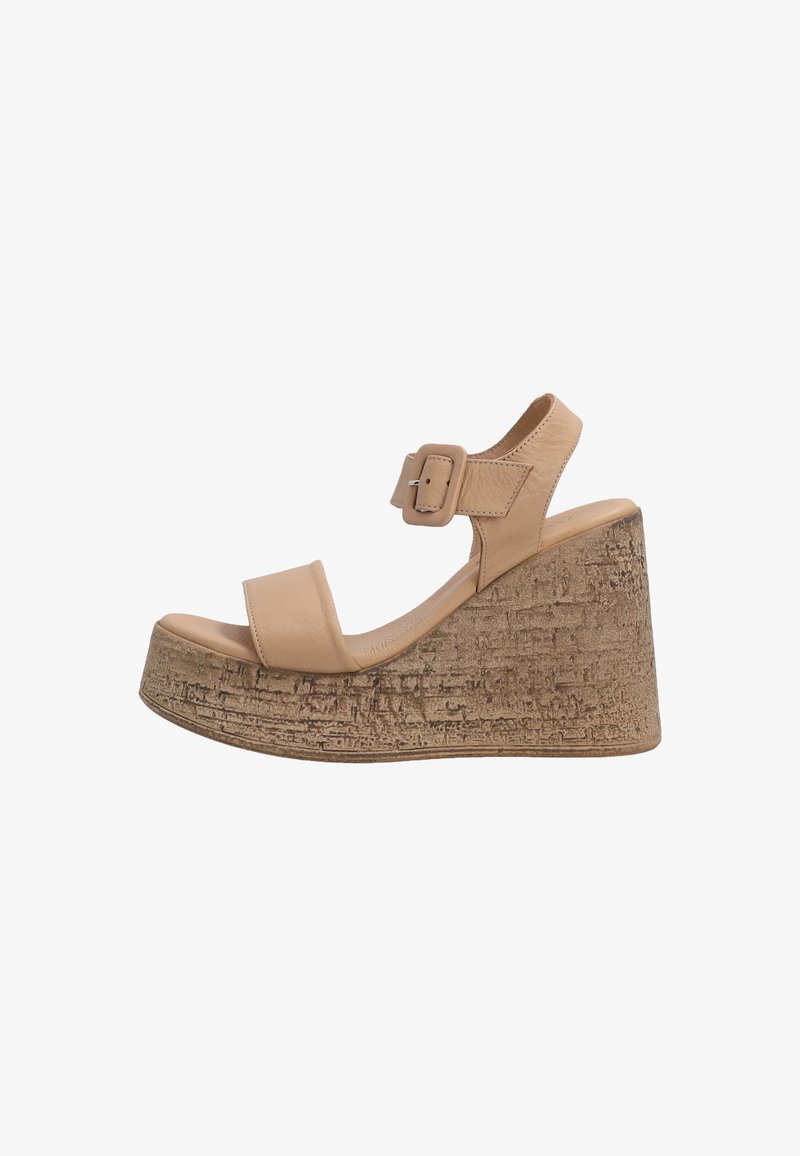 Béžové kožené sandály na klínu s dvěma širokými pásky a nastavovacím přezkovým uzávěrem. Texturovaná korková platforma má přírodní, drsný vzhled.