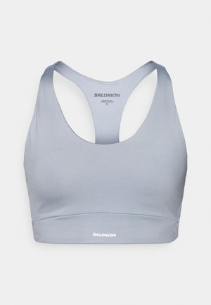 Light blue sports bra with a racerback design. Smooth, stretchy fabric and a small white logo at the front. Casual fit.