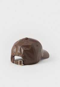 Gorra de béisbol de cuero marrón con correa ajustable, logo en relieve, corona redondeada y acabado texturizado. La vista posterior muestra la correa y la hebilla.