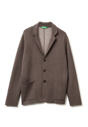 Bruine gebreide blazer met een notched kraag, vier zwarte knopen en twee voorzakken. Zachte textuur, relaxte pasvorm en open voorkant.