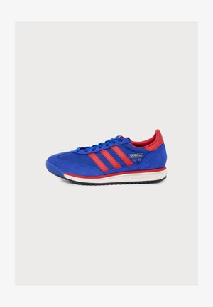 Modro-červený sneaker Adidas SL '72 s červenými pruhmi, modrými šnúrkami a bielou podrážkou, zobrazený z boku na bielom pozadí.