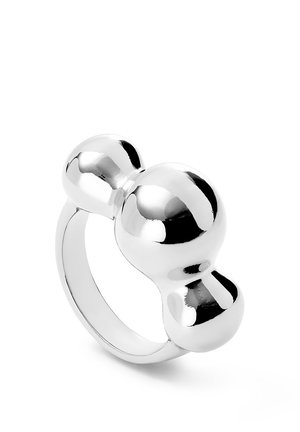 Anillo de metal plateado con tres formas esféricas pulidas conectadas como elemento decorativo superior.