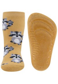 Gelbe Socken mit Waschbär-Muster, ausgestattet mit einer strukturierten Oberfläche und geripptem Bündchen; die Rückseite zeigt eine glatte Sohle mit Grip-Details.