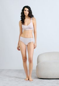 Απαλό ροζ ασύρματο σουτιέν και ταιριαστό μεσομεσογειακό σλιπ από απαλό ύφασμα. Μινιμαλιστικός σχεδιασμός με μαλακές άκρες και άνετη εφαρμογή.