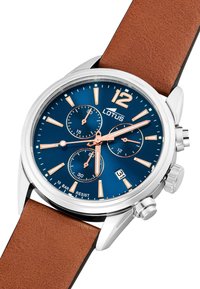 Reloj cronógrafo de tono plateado con esfera azul, correa de cuero marrón y acentos en oro rosa. Cuenta con tres subesferas y una pantalla de fecha.