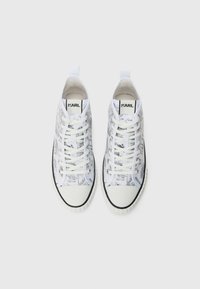 Høye sneakers med hvit og svart grafisk trykk, med hvite snørebånd og en svart gummisåle med et teksturert mønster.