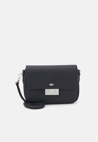 Sac de crossbody synthétique noir avec un fermoir rabat, quincaillerie en argent et surface texturée. Comprend un détail de logo et une bandoulière ajustable.