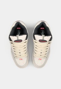 White leather sneakers with grey accents, rounded toe, beige laces, and red logo detail. Textured tongue and cushioned interior.