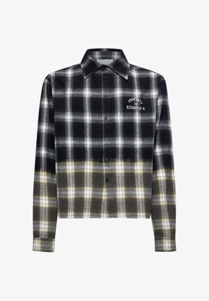 Camicia a scacchi in bianco e nero con accenti gialli, design cropped, chiusura con bottoni frontale e testo ricamato sul petto. Realizzata in materiale flanella.
