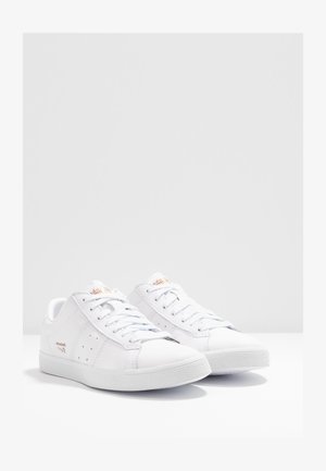 Valkoiset urheilukengät, joissa on sileä nahkapinta, tasaiset nauhat, määrätyt sivut, kumipohjat ja huomaamattomat brändivaihtoehdot.