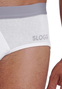 Weiße Unterhose mit elastischem, hellgrauem Bund, der das "SLOGGI"-Logo trägt. Hergestellt aus weichem Stoff, der eng anliegt und mit minimalen Nähten gestaltet ist.