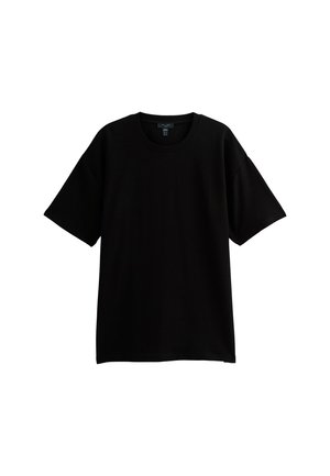 T-shirt nera a maniche corte realizzata in tessuto a coste, con scollatura rotonda e vestibilità ampia. Nessun logo o motivo visibile.