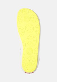Shoe insole with a bright yellow rubber bottom featuring circular tread patterns and textures, bordered in gray and white.