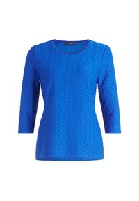 Bluzka z długim rękawem w jasnoniebieskim kolorze, o fakturze z sześciokątnymi wzorami. Posiada okrągły dekolt i jest wykonana z miękkiego materiału, w wąskim kroju.