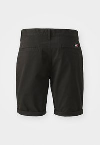 Pantaloni corti neri in cotone, con fronte piatto, orli risvoltati, due tasche posteriori e una piccola etichetta del marchio sul retro.