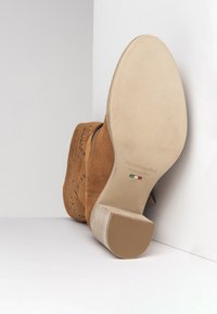 Braune Wildleder-Ankle-Boots mit einem strukturierten Lederabsatz, verziert mit kunstvollen Aussparungen und einer glatten beigefarbenen Sohle. Größe 37, hergestellt in Italien.