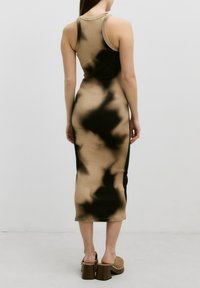 Enganliegendes, ärmelloses Midikleid aus dehnbarem Stoff mit einem beige-schwarzen Batikmuster; besitzt einen Rundhalsausschnitt und eine figurbetonte Silhouette.