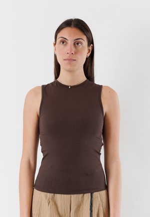 Top senza maniche marrone realizzato in tessuto morbido, caratterizzato da un design aderente e un colletto rotondo, abbinato a pantaloni leggeri plissettati.
