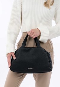 Sac à main en cuir noir avec une finition texturée, de forme arrondie et à doubles poignées. Présente un logo doré subtil à l'avant.