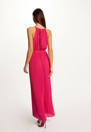 Farkunsävyinen sifonkipuku, jossa on halter-kaulus, joustava vyötärönauha ja avoin selkädetaili. Yhdistetty mustiin ja vaaleanpunaisiin korkokenkiin.