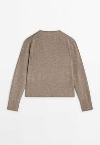 Beige neulepusero, jossa on pyöreä pääntie, resorit helman ja hihansuiden kohdalla sekä rento siluetti, jotka korostavat pehmeää ja teksturoitua kangasta.