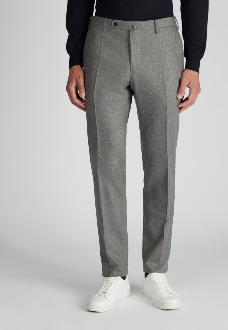 Graue Hose mit tailliertem Schnitt, strukturiertem Stoff, Seitentaschen und vorderen Falten, kombiniert mit weißen Turnschuhen.