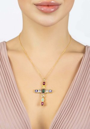 Collier en croix en or ornée de pierres précieuses multicolores, comprenant du rouge, du vert et du violet, sur une chaîne délicate. Fond texturé.