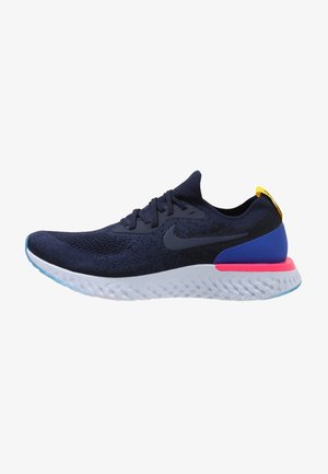 Chaussure de course Nike bleu marine avec semelle extérieure blanche texturée, accent de semelle intermédiaire rose, soutien du talon bleu et languette de traction jaune.