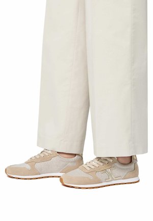 Sneaker beige con un mix di materiali in mesh e suede, con un design testurizzato e suola bianca. Abbinati a pantaloni larghi beige chiaro.
