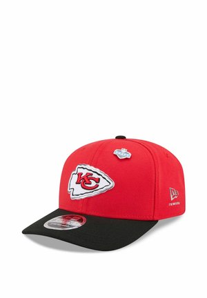 Rot-schwarze Kansas City Chiefs Kappe mit Logo-Aufnäher vorne, NFL Draft Anstecker oben und New Era Logo an der Seite.