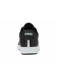 Černé kožené tenisky s bílou podrážkou, vybavené zesílenou patou, logem K-Swiss na zadní straně a jemnými černými a šedými akcentovými pruhy.