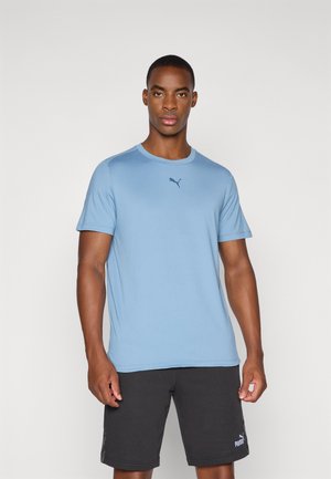 Lyseblå T-shirt med korte ærmer lavet af blødt stof. Har rund hals og et diskret mørkeblåt Puma-logo på brystet.