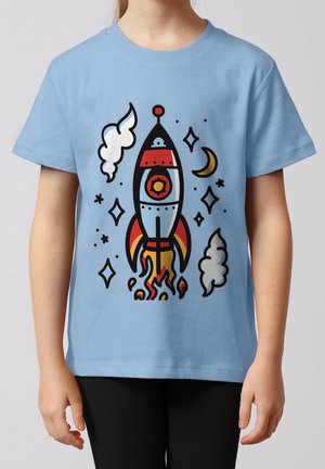 Kind trägt hellblaues T-Shirt mit bunter Comic-Rakete beim Start, umgeben von Sternen, Rauchwolken und einer Mondsichel.