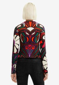 Košile s dlouhým rukávem s odvážným, vícolorým abstraktním květinovým vzorem s zelenými, červenými a černými akcenty, vyrobená z hladkého materiálu.