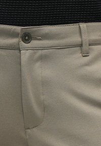 Beige skräddarsydda byxor med rak front, enkel knappstängning och en mjuk textur. Inkluderar bältesslingor och sidofickor.