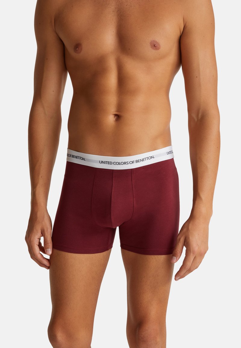 Boxer da uomo bordeaux con una vita elastica bianca su cui è presente il logo "UNITED COLORS OF BENETTON". Tessuto in cotone morbido e elasticizzato.