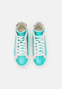 Wysokie sneakersy z turkusową syntetyczną cholewką, beżowymi zamszowymi akcentami, białymi sznurówkami oraz teksturowaną podeszwą.