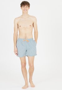 Gestreifte Badeshorts in Hellblau und Weiß, mit oranger Kordel und Seitentaschen, sowie einem kleinen Logo am linken Bein.