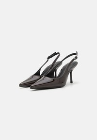 Barna lakkbőr slingback sarkú cipők hegyes orral, elegáns vonalvezetéssel és keskeny boka pánttal, fémcsattal kiemelve.